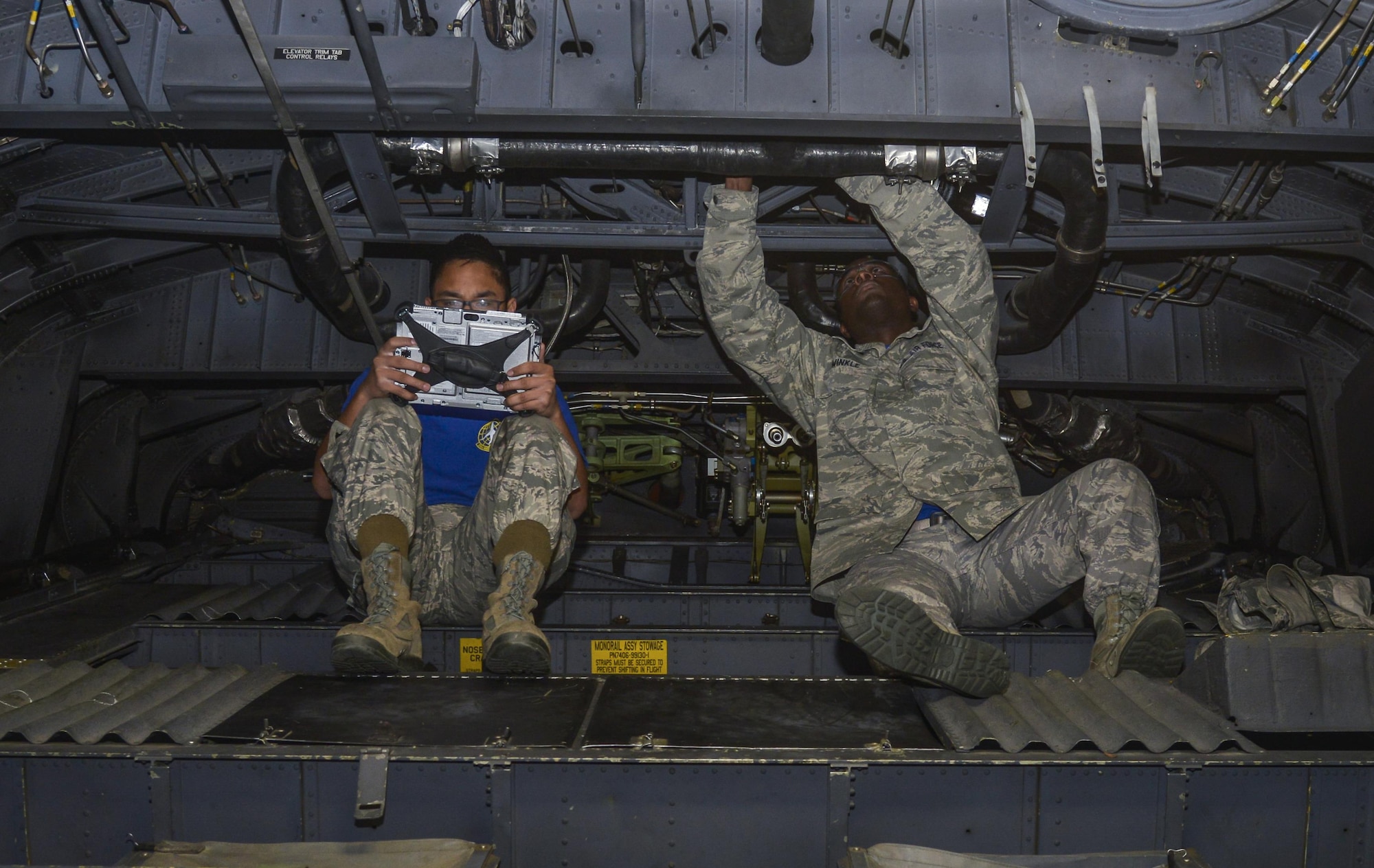 Airman 1st Class Mark Dimaapi and Staff Sgt. Tahgie Winkle, both 374th Maintenance Flight electrical environmental specialists, install a filter on an MC-130 Talon II at Yokota Air Base, Japan, Feb. 26, 2016. Once the four maintenance phases are completed, the phase dock crew reattaches the panels to the aircraft, conducts the final engine runs and complete any final checks. (U.S. Air Force photo by Senior Airman David Owsianka/Released)