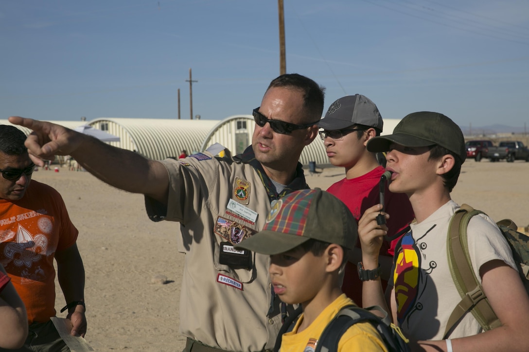 Chief Warrant Officer 2 Brandon Fenstermaker, troop leader, provides directions to boy scouts with Troop 77 prior to beginning a land navigation exercise during a Boy Scout Camp Out at Camp Wilson, March 19, 2016. (Official Marine Corps photo by Cpl. Medina Ayala-Lo/Released)