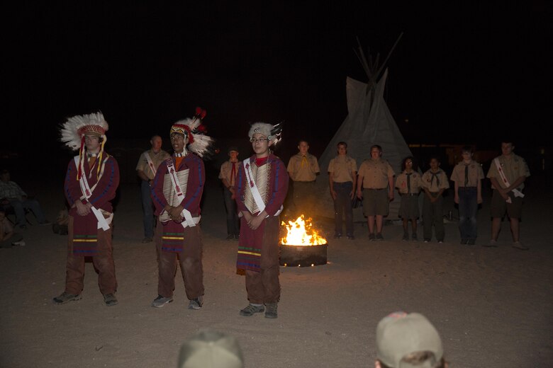 Order of the Arrow nominees stand on line as three members of the order, dressed in Native American regalia to honor the past, give background on what the nomination of the scouts behind them signifies during their Call Out Ceremony at Camp Wilson as part of the Boy Scout Camp Out for local Boy Scouts of America troops March 18, 2016. The annual ceremony selects scouts who were nominated by their peers for exemplary scouting skills, leadership and willingness to learn. The order is an honor society within the organization symbolized by a white sash with a red arrow for members who have been officially accepted. (Official Marine Corps photo by Sgt. Charles Santamaria/Released)