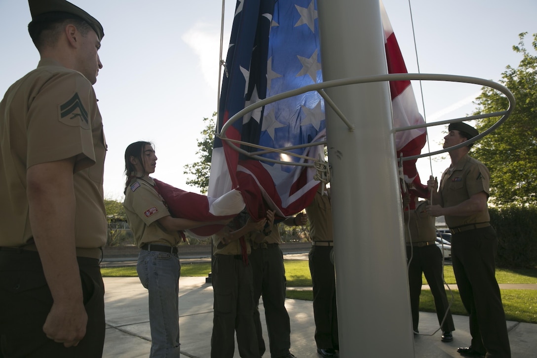 Marines from Headquarters Battalion help boy scouts from Boy Scouts of America troops 72, 77, 78 and 180 unravel and hold onto the national colors before the playing of morning colors at Lance Cpl. Torrey L. Gray Field as part of the Boy Scout Camp Out March 20, 2016. (Official Marine Corps photo by Cpl. Medina Ayala-Lo/Released)