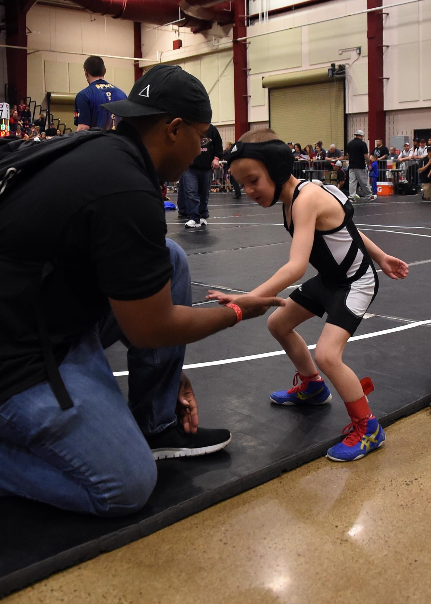 Staff Sgt. Morris Thomas, the Children of Valor wrestling team coach, gives Ian Greer a low-five before his first match at the state wrestling competition in Castle Rock, Colo., Feb. 28, 2016. Children of Valor has only been a team for 11 months, but placed fifth out of 191 teams during the tournament. (U.S. Air Force photo/Staff Sgt. Deborah Lockhart)