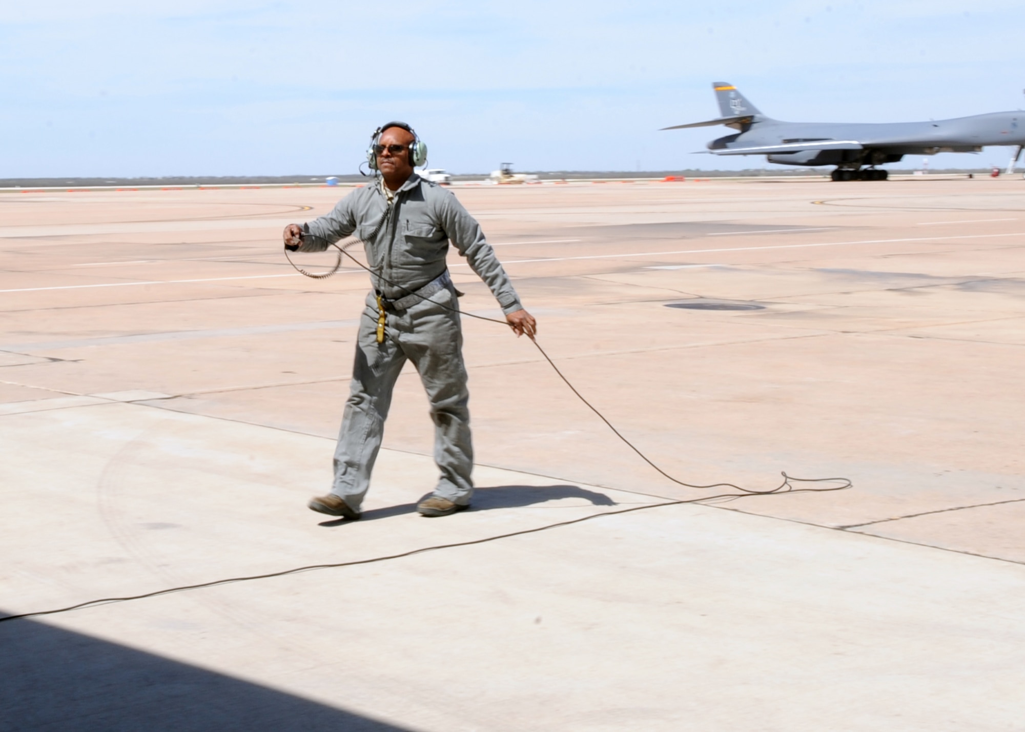 U.S. Air Force Tech. Sgt. Terance Thomas, 489th Maintenance Squadron crewchief, runs a communication line to a B-1B Lancer, March 22, 2016, at Dyess Air Force Base, Texas. Thomas is an Air Reserve Technician, who works alongside active duty members during the week. The 489th Bomb Group was brought in to augment the work of active duty members through Total Force Integration. (U.S. Air Force photo by Senior Airman Shannon Hall/Released)