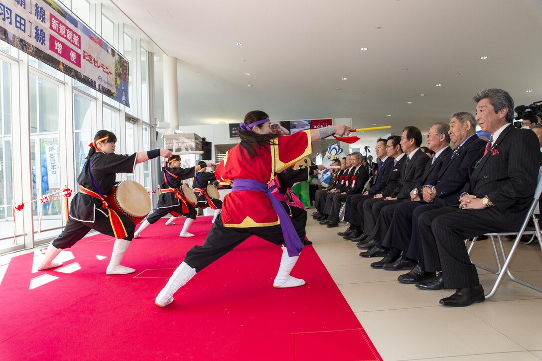 The Iwakuni Kintaikyo Airport Use Promotion Council and distinguished guests celebrate the addition of two new flights to the Iwakuni Kintaikyo Airport, March 27, 2016. The celebration included an Eisaa Okinawa Drum Demonstration, a Ryuky-Koku-Matsuri Daiko Drum performance and a ribbon cutting ceremony. Distinguished guests expressed their appreciation toward the Ministry of Defense, Ministry of Land, Infrastructure, and Transport, MCAS Iwakuni and other organizations involved in the adoption of these new flights. The airport and additional flights will contribute to the exchange of people and culture among Iwakuni, Okinawa and other Asian countries. (U.S. Marine Corps photo by Sgt. Antonio J. Rubio)
