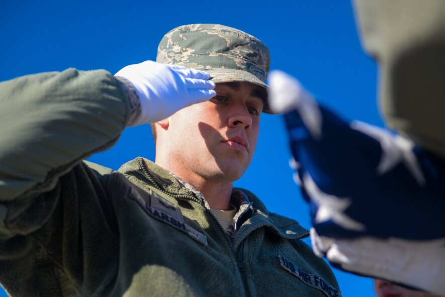 Senior Airman Jonathan Marsh, an airfield system journeyman assigned to the 5th Operations Support Squadron, salutes the flag after it was lowered during an honor guard practice at Minot Air Force Base, N.D., March 10, 2016.  All members of Minot AFB Honor Guard have volunteered their time to be a part of this tradition. (U.S. Air Force photo/Airman 1st Class Jessica Weissman)