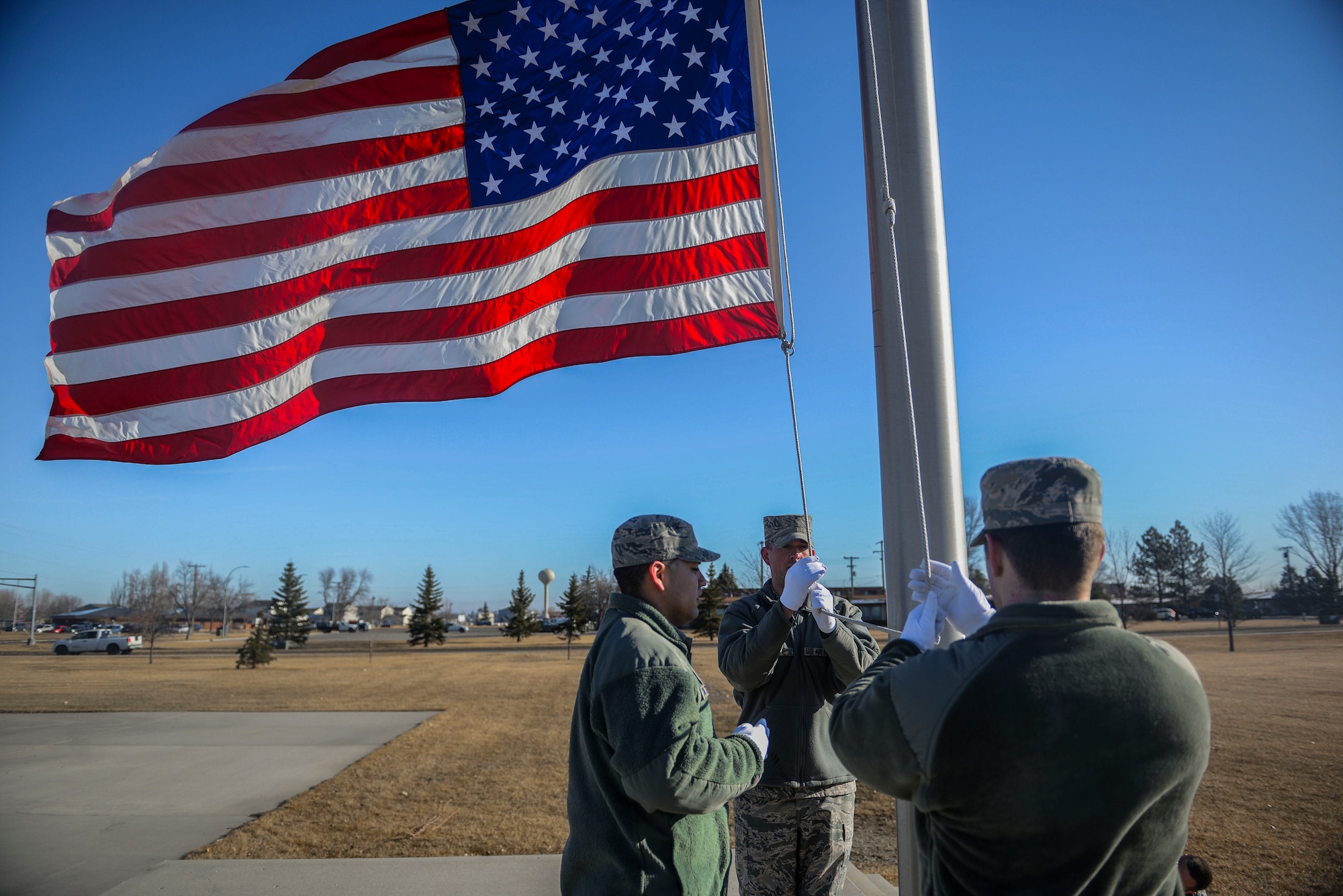 Members of the Honor Guard lower the flag during practice at Minot Air Force Base, N.D. March 10, 2016. The core mission of the United States Air Force Honor Guard is to provide military funeral honors to veterans and retirees of the Air Force. (U.S. Air Force photo/Airman 1st Class Jessica Weissman)