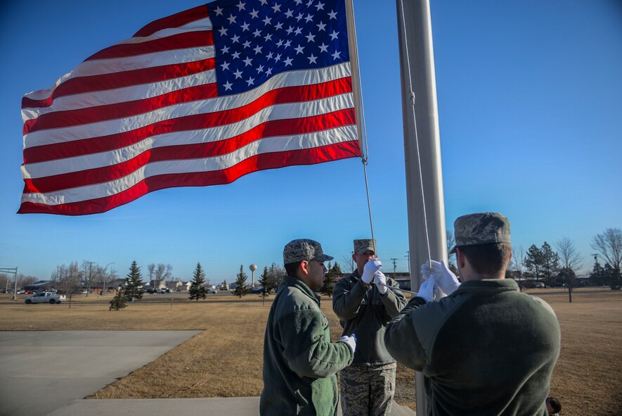 Members of the Honor Guard lower the flag during practice at Minot Air Force Base, N.D. March 10, 2016. The core mission of the United States Air Force Honor Guard is to provide military funeral honors to veterans and retirees of the Air Force. (U.S. Air Force photo/Airman 1st Class Jessica Weissman)