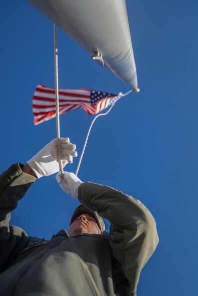 Tech. Sgt. Joshua Hull, the program manager of the Honor Guard, raises the flag during a practice at Minot Air Force Base, N.D. March 10, 2016. Hull says the most rewarding thing from being a guardsman is gaining a deeper respect for military traditions. (U.S. Air Force photo/Airman 1st Class Jessica Weissman)