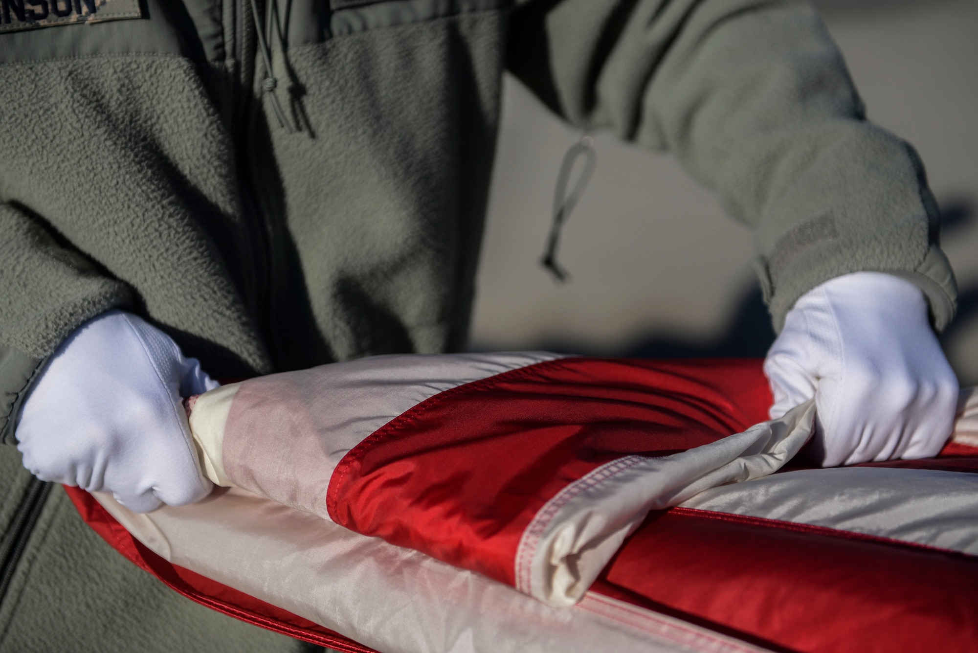 A member of the Honor Guard folds the flag during practice at Minot Air Force Base, N.D., March 10, 2016. The core mission of the United States Air Force Honor Guard is to provide military funeral honors to veterans and retirees of the Air Force. (U.S. Air Force photo/Airman 1st Class Jessica Weissman)