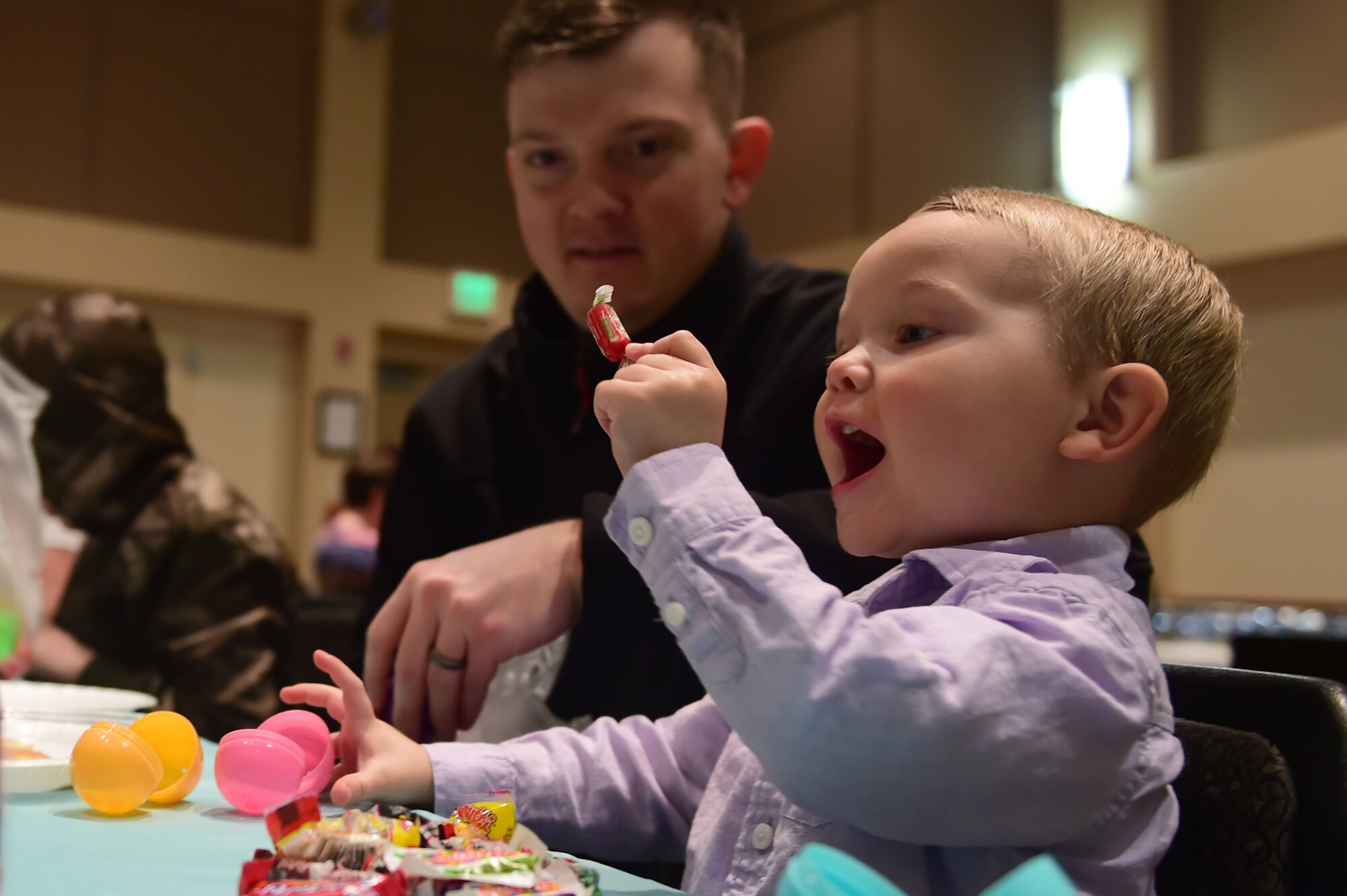 A boy from the Buckley community opens an Easter egg to find a piece of candy March 26, 2016, at the Leadership Development Center on Buckley Air Force Base, Colo. Families attended the annual event, which provides a free pancake breakfast along with hundreds of Easter eggs for the children. (U.S. Air Force photo by Airman 1st Class Luke W. Nowakowski/Released)