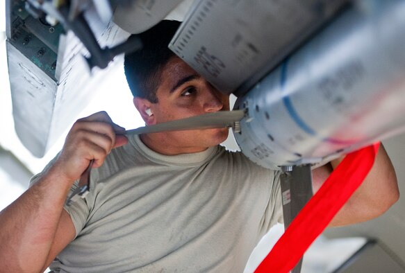 Senior Airman Giovanni Bufalini-Balla, 96th Aircraft Maintenance Squadron Red team, secures a fin to an AIM-120 missile on an F-15 Eagle March 25 at Eglin Air Force Base, Fla.  The Red team battled the Blue AMU team for weapons loadcrew supremacy during the quarterly competition.  The Red team claimed victory this quarter.  (U.S. Air Force photo/Samuel King Jr.)
