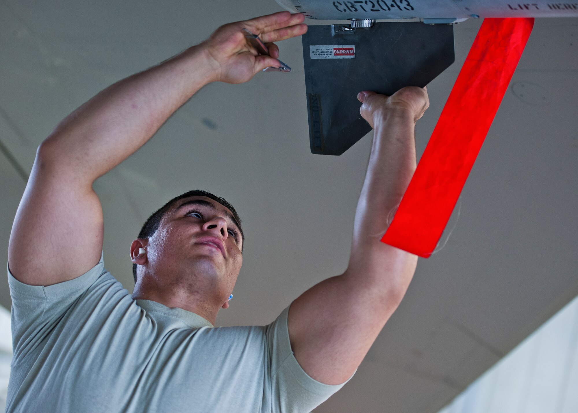 Senior Airman Giovanni Bufalini-Balla, 96th Aircraft Maintenance Squadron Red team, secures a fin to an AIM-120 missile on an F-15 Eagle March 25 at Eglin Air Force Base, Fla.  The Red team battled the Blue AMU team for weapons loadcrew supremacy during the quarterly competition.  The Red team claimed victory this quarter.  (U.S. Air Force photo/Samuel King Jr.)