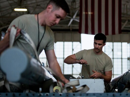 Members of the 96th Aircraft Maintenance Squadron Blue team perform checks on an AIM-120 missile they will be loading onto an F-16 Fighting Falcon March 25 at Eglin Air Force Base, Fla.  The Blue team battled the Red AMU team for weapons loadcrew supremacy during the quarterly competition.  The Red team claimed victory this quarter.  (U.S. Air Force photo/Samuel King Jr.)