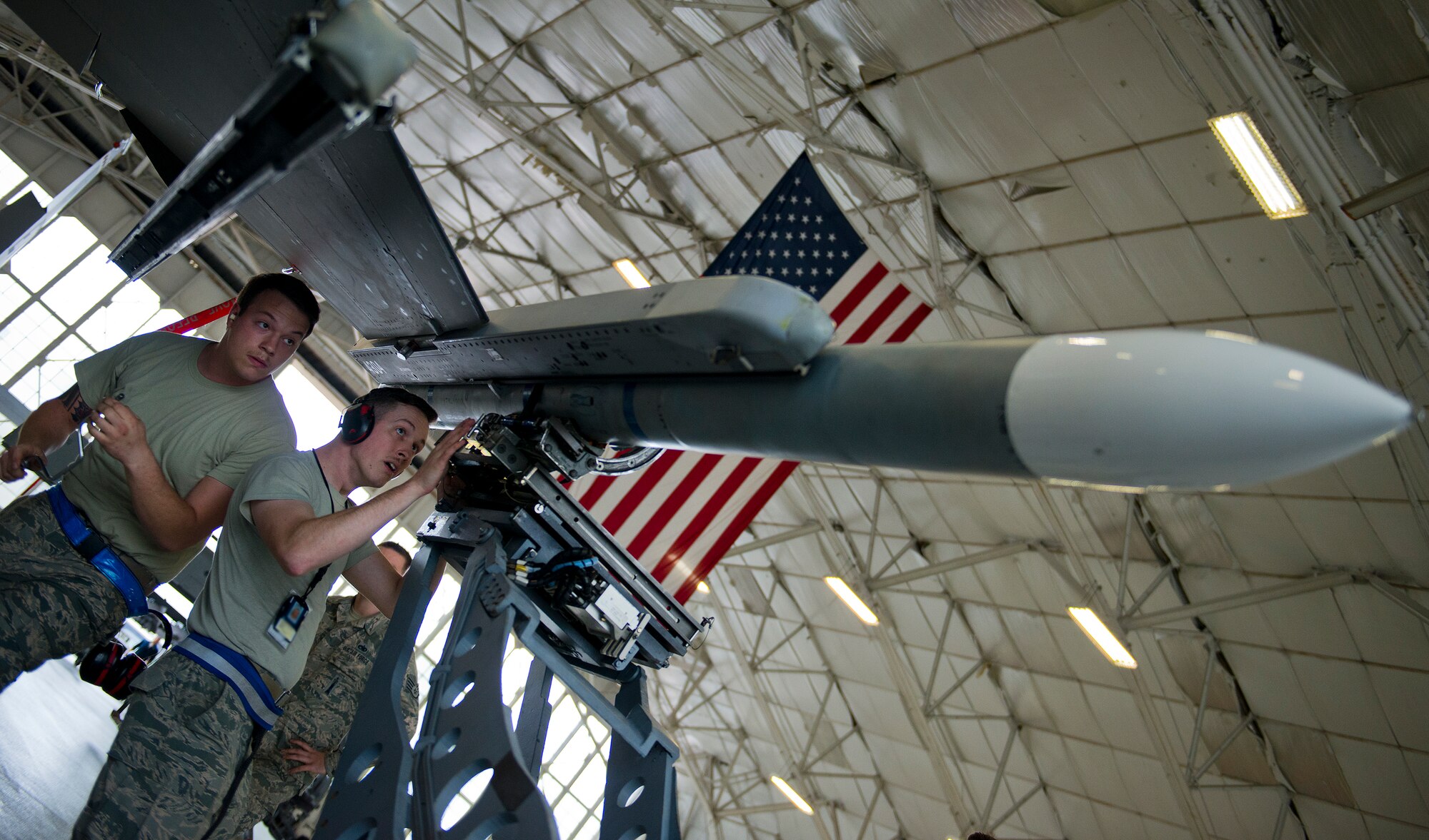 The 96th Aircraft Maintenance Squadron Blue team loads an AIM-120 missile onto an F-16 Fighting Falcon March 25 at Eglin Air Force Base, Fla.  The Blue team battled the Red AMU team for weapons loadcrew supremacy during the quarterly competition.  The Red team claimed victory this quarter.  (U.S. Air Force photo/Samuel King Jr.)