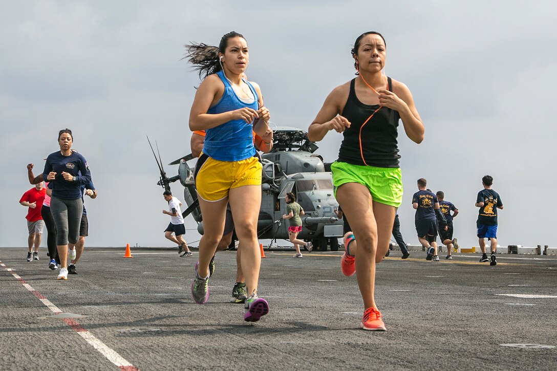 Marine Corps Sgts. Priscilla Castillo and Liliana Sandoval listen to music as they participate in a 5-kilometer run for Women's History Month aboard the USS Boxer in the Pacific Ocean, March 27, 2016. Castillo and Sandoval are assigned to the 13th Marine Expeditionary Unit. Marine Corps photo by Sgt. Briauna Birl