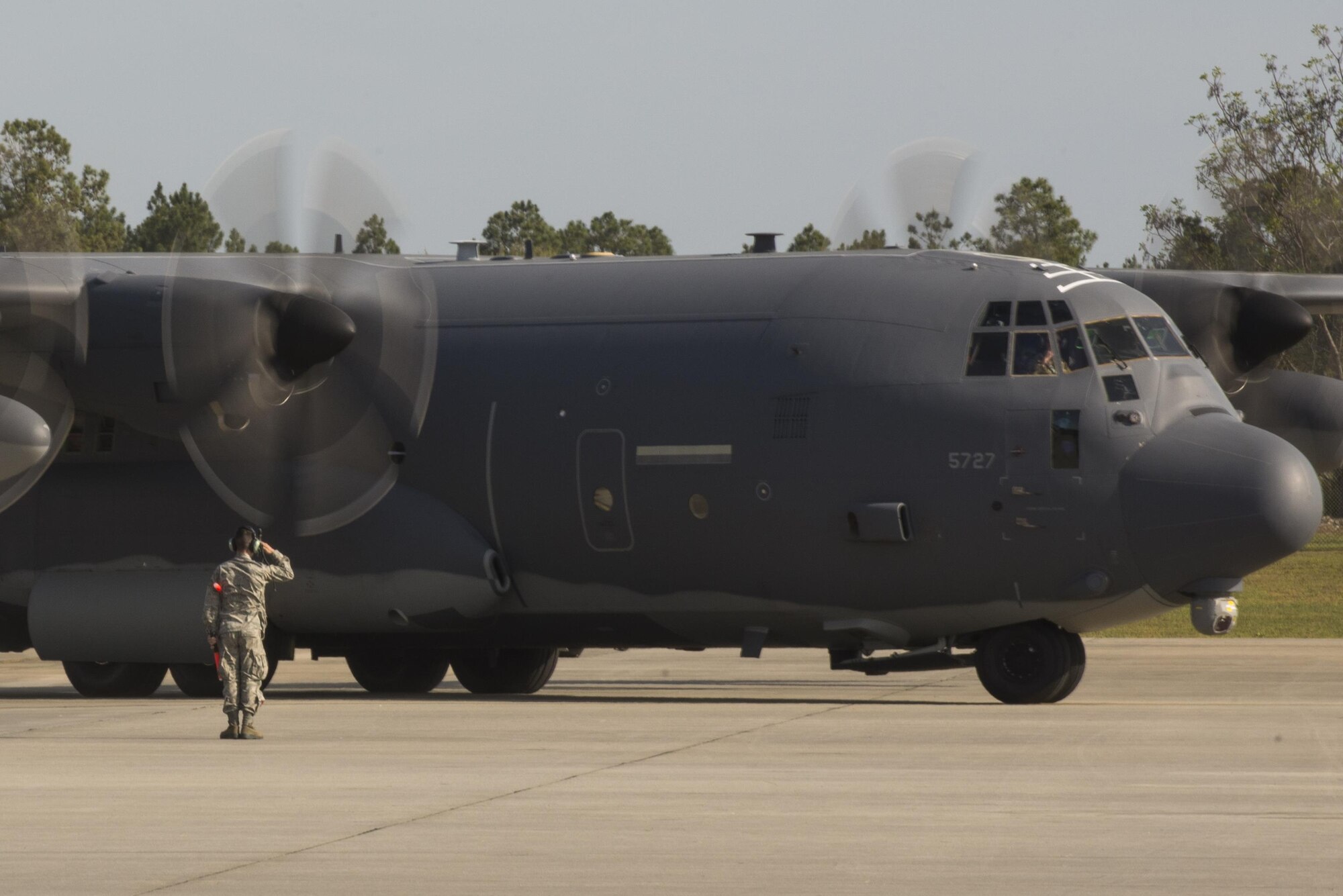 U.S. Air Force Senior Airman Ryan Culbertson, 71st Aircraft Maintenance Squadron HC-130J Combat King II crew chief, salutes the aircraft and crew as they depart for their deployment, March 24, 2016, at Moody Air Force Base, Ga. The HC-130J is equipped with infrared radar and missile warning receivers and the ability to receive fuel in-flight. (U.S. Air Force photo by Airman Daniel Snider/Released)