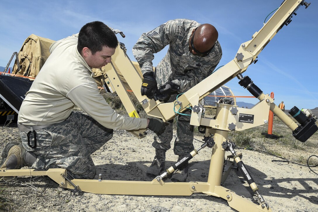 Air Force Chief Master Sgt. Marlon Taylor, right, and Air Force Senior Airman Andres Fong assemble a small aperture terminal dish during Exercise Turbo Distribution 16-02 at Amedee Army Airfield, Calif., March 15, 2016. Taylor is a superintendent assigned to the 821 Contingency Response Group. Fong is an initial communications element technician assigned to the 821st Contingency Response Support. The dish provides a satellite communication shot to enable Defense Department networks to transmit classified and nonclassified information. Air Force photo by Staff Sgt. Robert Hicks