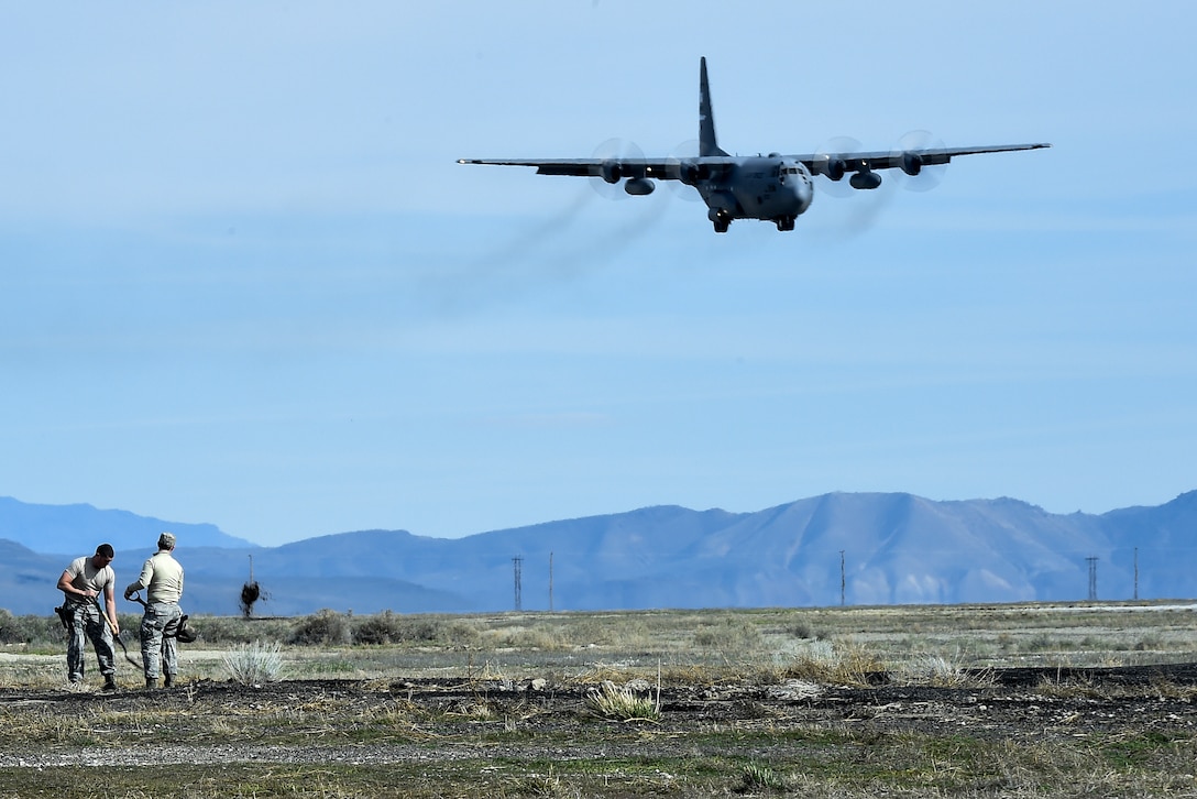Airmen build a defense fighting position as a C-130 Hercules aircraft prepares to land during Exercise Turbo Distribution 16-02 at Amedee Army Airfield, Calif., March 15, 2016. Air Force photo by Staff Sgt. Robert Hicks 