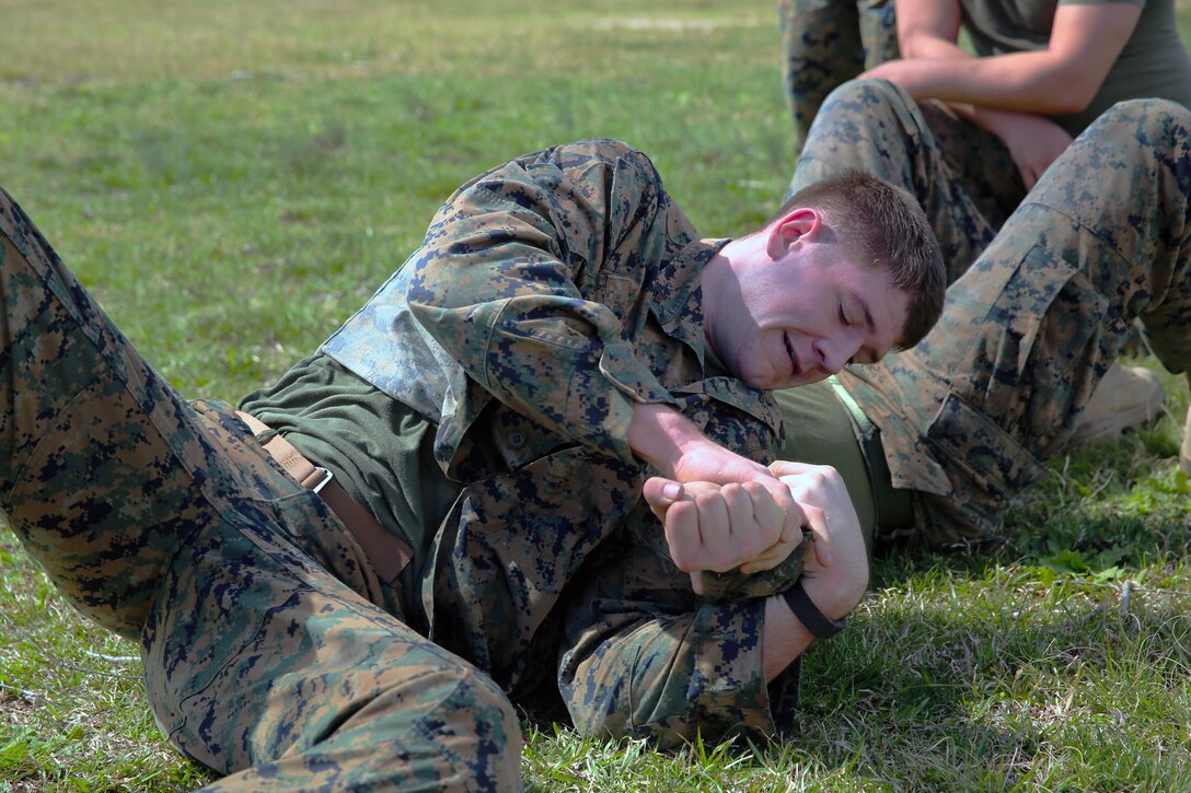 Cpl. Thomas Sterk grapples with another Marine during a team building exercise after completing the obstacle course at Marine Corps Air Station Cherry Point, N.C., March 18, 2016. The obstacle course is utilized as a confidence builder for Marines as it challenges their physical and mental strength while encouraging leadership skills. Sterk is a food service specialist with Headquarters and Headquarters Squadron. (U.S. Marine Corps photo by Lance Cpl. Mackenzie Gibson /Released)