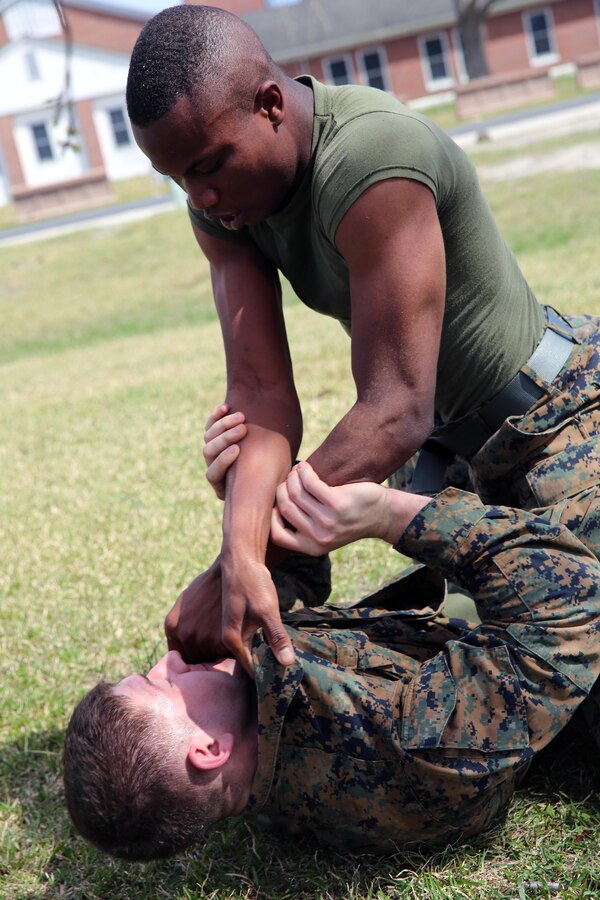 Marines with Headquarters and Headquarters Squadron grapple during a team building exercise after completing the obstacle course at Marine Corps Air Station Cherry Point, N.C., March 18, 2016. The obstacle course is utilized as a confidence builder for Marines as it challenges their physical and mental strength while encouraging leadership skills. (U.S. Marine Corps photo by Lance Cpl. Mackenzie Gibson /Released)