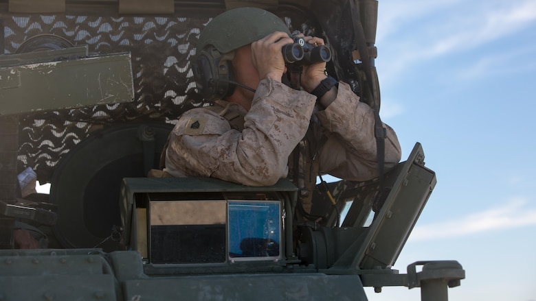 Sgt. Torry L. Broome, light armored vehicle crewman, Company B, 3rd Light Armored Reconnaissance Battalion, searches for potential threats through binoculars in the Combat Center training area March 23, 2016, during a Marine Corps Combat Readiness Evaluation Exercise. 3rd LAR conducted a five-day MCCREE to evaluate the combat readiness of B Co. 