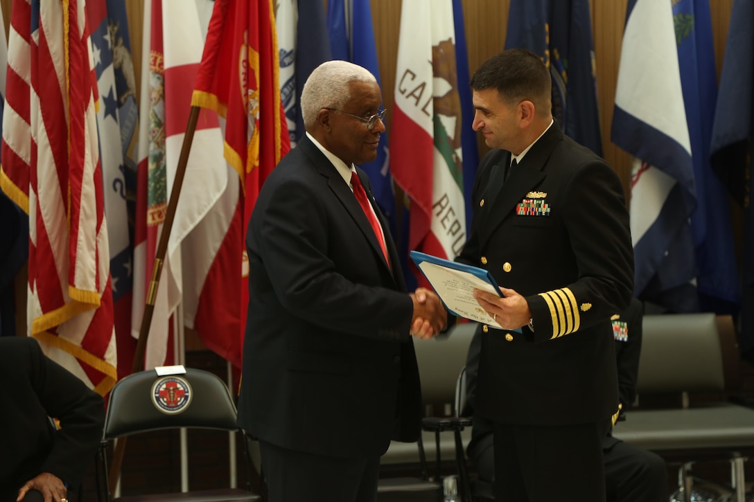 Navy Capt. Rick Freedman, right, Naval Hospital Camp Lejeune commanding officer, congratulates Raymond Applewhite, left, NHCL public affairs director, on his retirement at the hospital quarterdeck on Marine Corps Base Camp Lejeune Dec. 18. Applewhite enlisted in the Navy in 1971, served at the hospital for his first duty station and retired as a senior chief hospital corpsman after 22 years in the Navy. After his service in the Navy, Applewhite returned to the hospital for civil service. (U.S. Marine Corps photo by Cpl. Mark Watola /released)