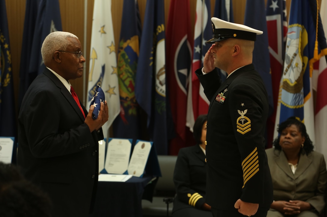 Raymond Applewhite, left, NHCL public affairs director, is presented with an American flag for his service during his retirement ceremony at the hospital quarterdeck on Marine Corps Base Camp Lejeune Dec. 18. Applewhite enlisted in the Navy in 1971, served at the hospital for his first duty station and retired as a senior chief hospital corpsman after 22 years in the Navy. After his service in the Navy, Applewhite returned to the hospital for civil service. (U.S. Marine Corps photo by Cpl. Mark Watola /released)