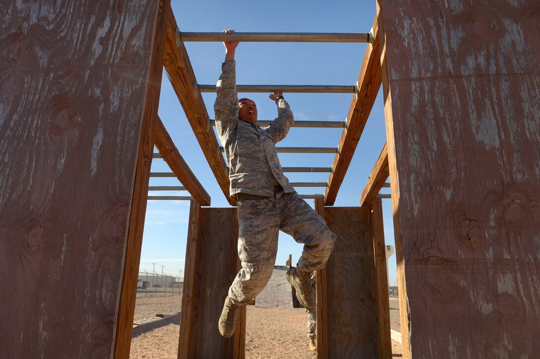 An airman negotiates the horizontal ladders obstacle during Operational Contract Support Joint Exercise 2016 at Fort Bliss, Texas, March 22, 2016. Air Force photo by Staff Sgt. Jonathan Snyder