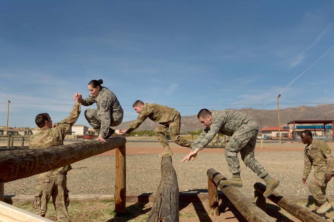 Soldiers and airmen negotiate the log ladder obstacle during Operational Contract Support Joint Exercise 2016 at Fort Bliss, Texas, March 22, 2016. Air Force photo by Staff Sgt. Jonathan Snyder