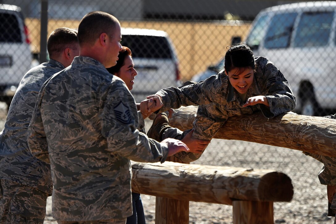 An airman negotiates an obstacle with help from teammates during Operational Contract Support Joint Exercise 2016 at Fort Bliss, Texas, March 22, 2016. Air Force photo by Staff Sgt. Jonathan Snyder 