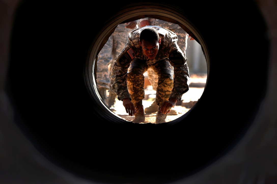 A soldier crawls through a concrete tunnel obstacle during Operational Contract Support Joint Exercise 2016 at Fort Bliss, Texas, March 22, 2016. Air Force photo by Staff Sgt. Jonathan Snyder