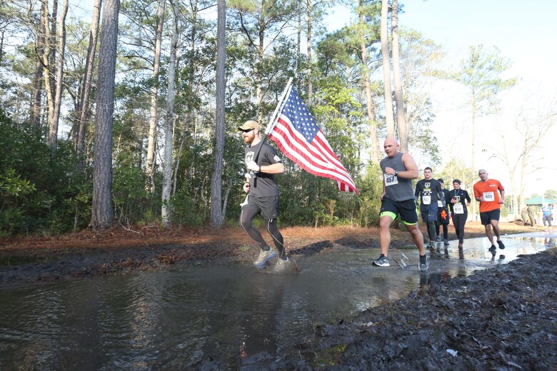 Participants race past the aviation memorial on Marine Corps Air Station New River during the Xtreme Endurance Challenge 12k+ held on Feb. 6. The X-treme Endurance Challenge 12k+ is part of Marine Corps Community Services Semper Fit Grand Prix races.  (U.S. Marine Corps photo by Cpl. Mark Watola /released)