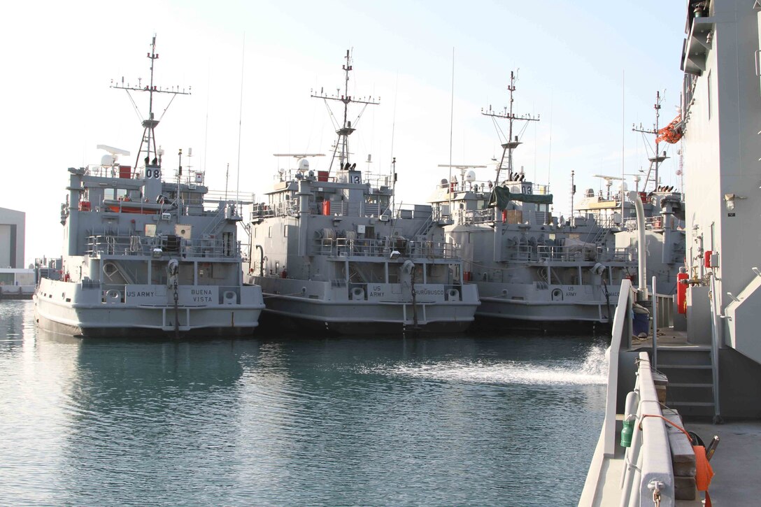 Landing Craft Utility boats sit in dock at the Kuwait Naval Base as part of APS-5 Kuwait, an army prepositioned wartime stocks program. APS-5 maintains over 30 Army watercraft in ready-for-issue condition as part of Army Central’s contingency operations strategy. (U.S. Army photo by Master Sgt. Dave Thompson, released)