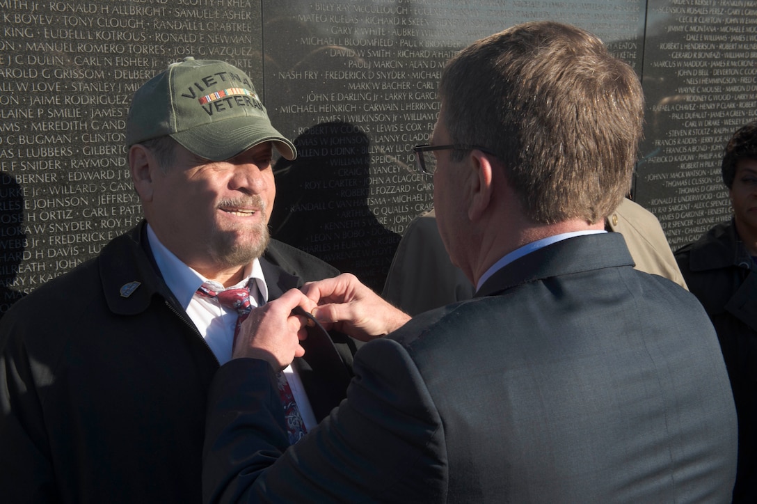 Defense Secretary Ash Carter puts a pin on a veteran at the Vietnam Veterans Memorial in Washington, D.C., March 29, 2016. DoD photo by Navy Petty Officer 1st Class Tim D. Godbee