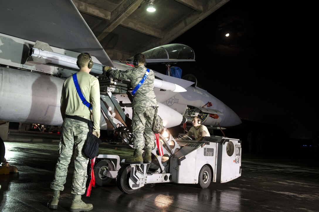 Air Force airmen load AIM-9X Sidewinder missiles onto an F-15 Eagle during a no-notice exercise at Kadena Air Base, Japan, March 18, 2016. The airmen are weapons loaders assigned to the 44th Aircraft Maintenance Unit. Air Force photo by Senior Airman Omari Bernard