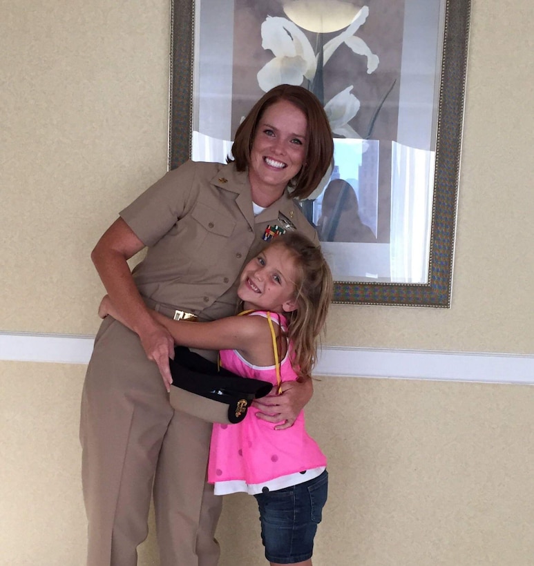 Chief Petty Officer Jaclyn Place runs to her daughter. Place is a lead chief petty officer with the Headquarters Regimental Aid Station, 1st Marine Logistics Group, and was awarded an impact Navy and Marine Corps Commendation Medal for her selfless and decisive actions that saved the lives of her neighbors. (U.S. Marine Corps photo by Sgt. Laura Gauna/released)