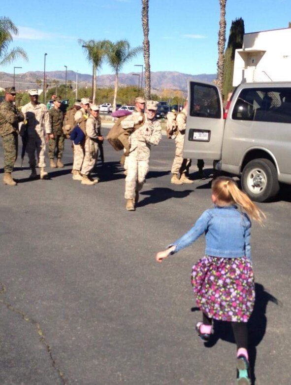 Chief Petty Officer Jaclyn Place runs to her daughter. Place is a lead chief petty officer with the Headquarters Regimental Aid Station, 1st Marine Logistics Group, and was awarded an impact Navy and Marine Corps Commendation Medal for her selfless and decisive actions that saved the lives of her neighbors. (U.S. Marine Corps photo by Sgt. Laura Gauna/released)