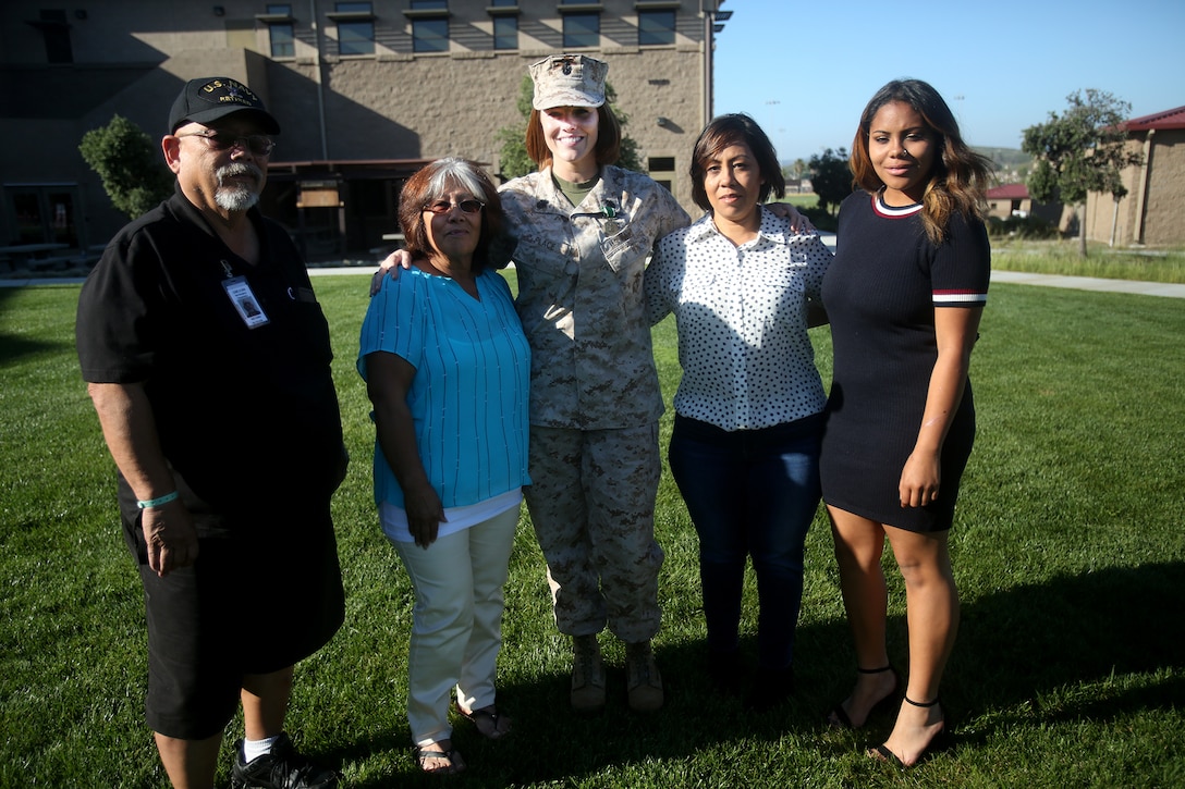 Chief Petty Officer Jaclyn Place poses for a photo with her neighbors and their family during Place’s award ceremony aboard Camp Pendleton, Calif., March 11, 2016. Place is a lead chief petty officer with the Headquarters Regimental Aid Station, 1st Marine Logistics Group, and was awarded an impact Navy and Marine Corps Commendation Medal for her selfless and decisive actions that saved the lives of her neighbors. (U.S. Marine Corps photo by Sgt. Laura Gauna/released)