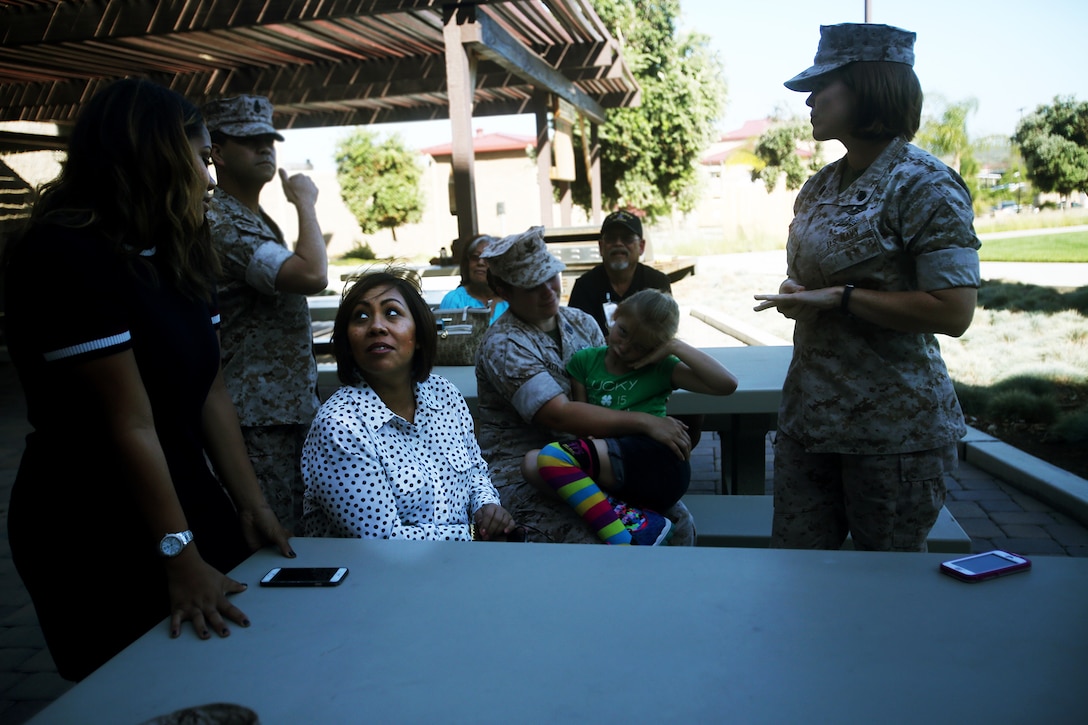 Chief Petty Officer Jaclyn Place waits with her neighbors during her award ceremony aboard Camp Pendleton, Calif., March 11, 2016. Place is a lead chief petty officer with the Headquarters Regimental Aid Station, 1st Marine Logistics Group, and was awarded an impact Navy and Marine Corps Commendation Medal for her selfless and decisive actions that saved the lives of her neighbors. (U.S. Marine Corps photo by Sgt. Laura Gauna/released)