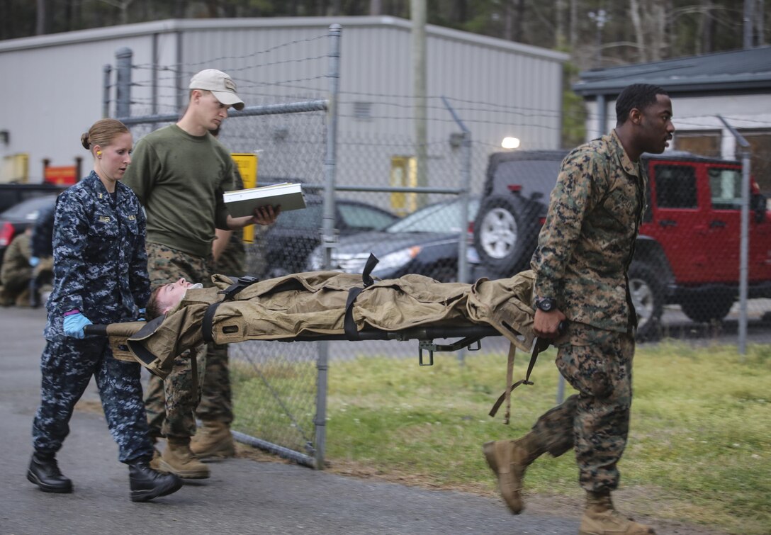 U.S. Navy Ensign Julia Mauer, a nurse, and Petty Officer 3rd Class Antoine Ensley, a hospital corpsman, both with 2nd Medical Battalion, carry a simulated casualty to a tent during a mass casualty training scenario at Camp Lejeune, N.C., March 25, 2016. The training was held to evaluate medical personnel capabilities in a field environment with limited manpower and resources. (U.S. Marine Corps photo by Cpl. Paul S. Martinez/Released)