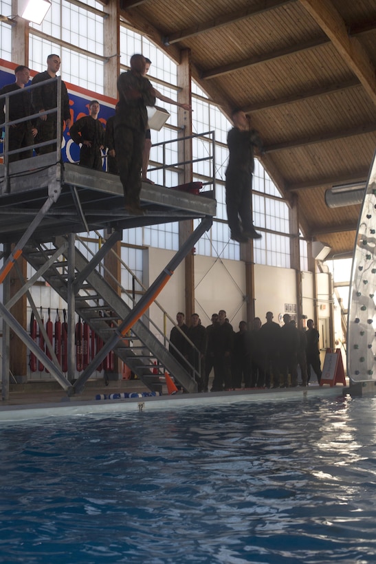 Marines dive off a platform to simulate an abandon ship procedure during basic swim qualification at Marine Corps Air Station Cherry Point, N.C., March 16, 2016. Marine Corps photo by Lance Cpl. Jered T. Stone