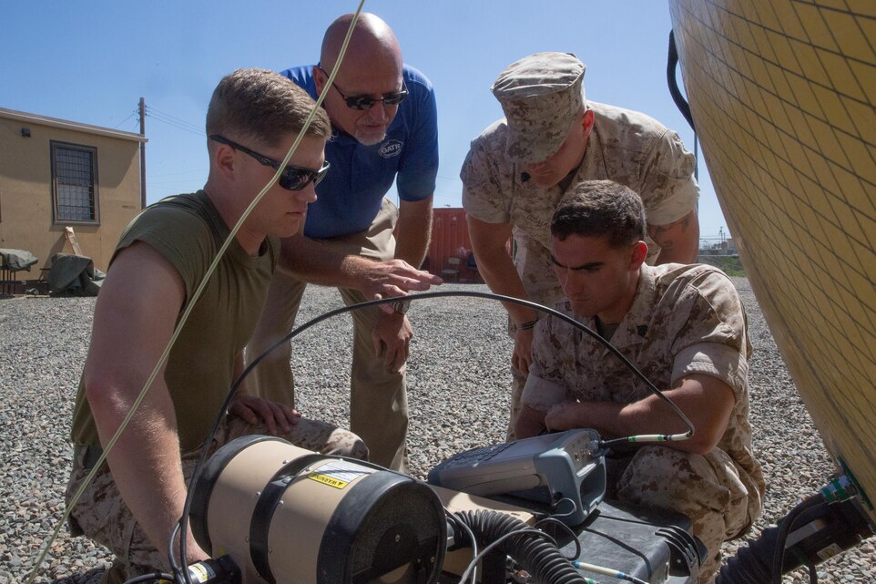 Matt Macon, a satellite communications operator contractor, shows field radio operators with the 11th Marine Expeditionary Unit how to use a satellite communications dish during a communications exercise (COMMEX) aboard Marine Corps Base Camp Pendleton, Calif., March 23, 2016. The COMMEX familiarizes Marines with the 11th MEU’s standing operating procedures regarding communications as they prepare to begin training or “work-ups” leading to the upcoming deployment.
