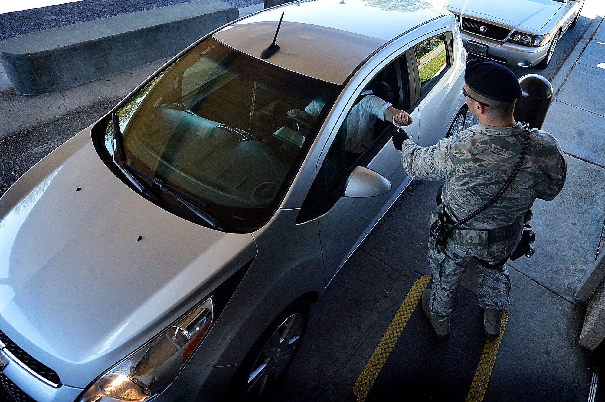 U.S. Air Force Senior Airman Samuel Montgomery, 20th Security Forces Squadron patrolman, inspects identification cards at the Main Gate at Shaw Air Force Base, S.C., March 29, 2016. 20th SFS Airmen are tasked with ensuring the security of the base and its assets while simultaneously protecting members of Team Shaw and their families. (U.S. Air Force photo by Senior Airman Michael Cossaboom)