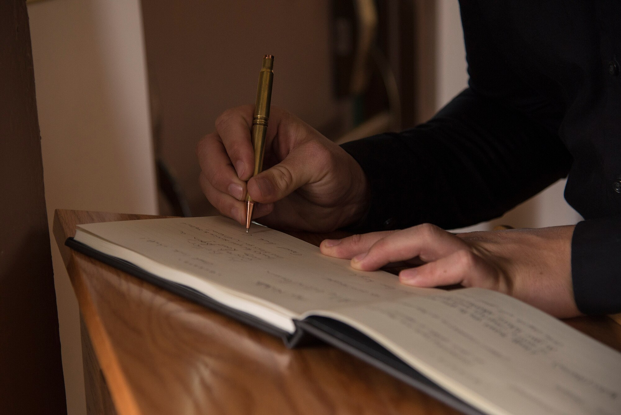 An attendee signs a guest book before the retirement ceremony of U.S. Air Force Chief Master Sgt. Manuel Camacho, 23d Security Forces Squadron manager, March 28, 2016, at Moody Air Force Base, Ga. Camacho promoted to the rank of chief in 2009; a rank only the top one percent of the enlisted Air Force attains. (U.S. Air Force photo by Airman 1st Class Janiqua P. Robinson/Released)