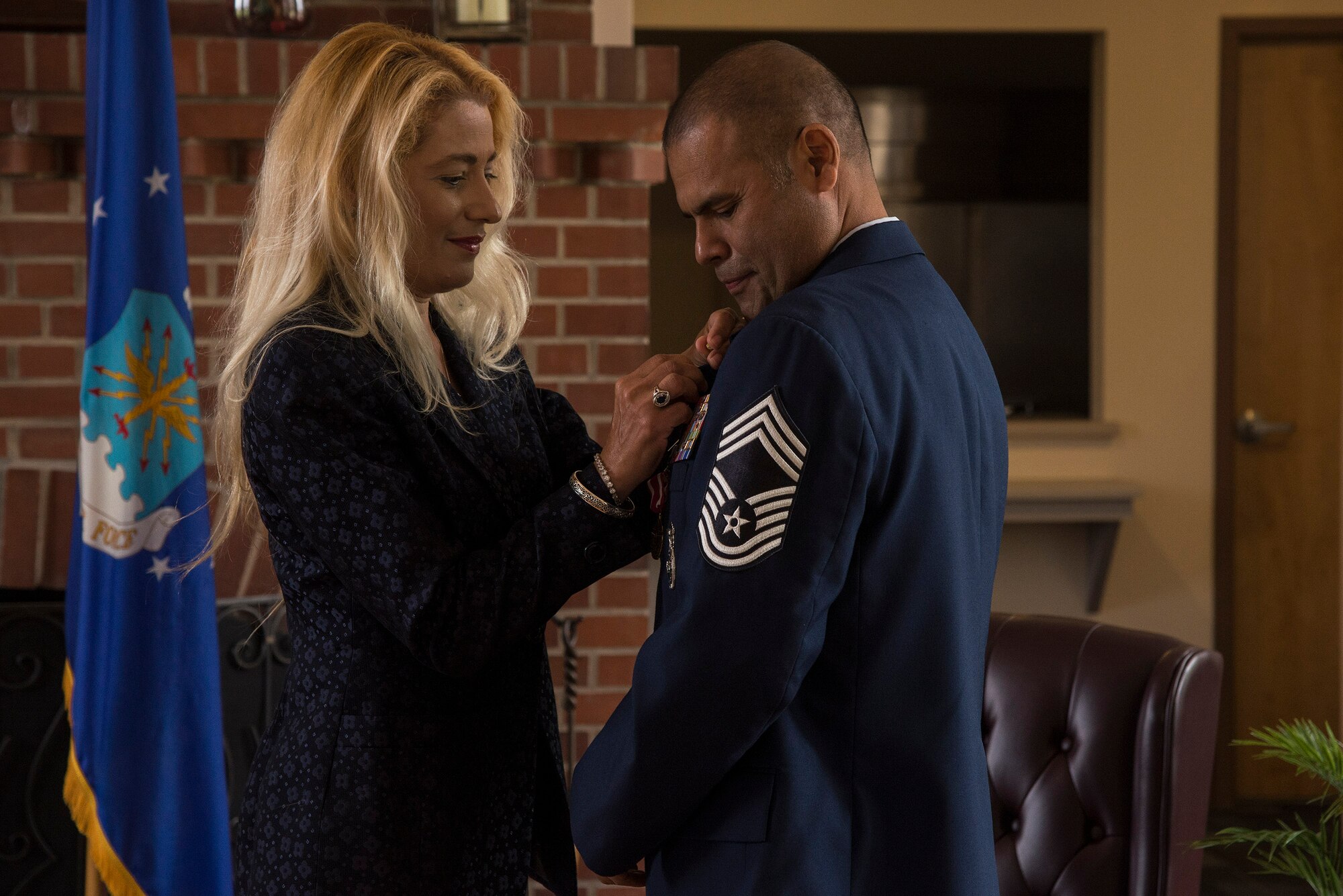 Rose Mary Camacho pins a retirement pin on her husband, U.S. Air Force Chief Master Sgt. Manuel Camacho, 23d Security Forces Squadron manager, during his retirement ceremony, March 28, 2016, at Moody Air Force Base, Ga. Camacho completed basic military training July 30, 1986 and then completed the Security Police Academy and Air Base Ground Defense School in September of the same year. (U.S. Air Force photo by Airman 1st Class Janiqua P. Robinson/Released)