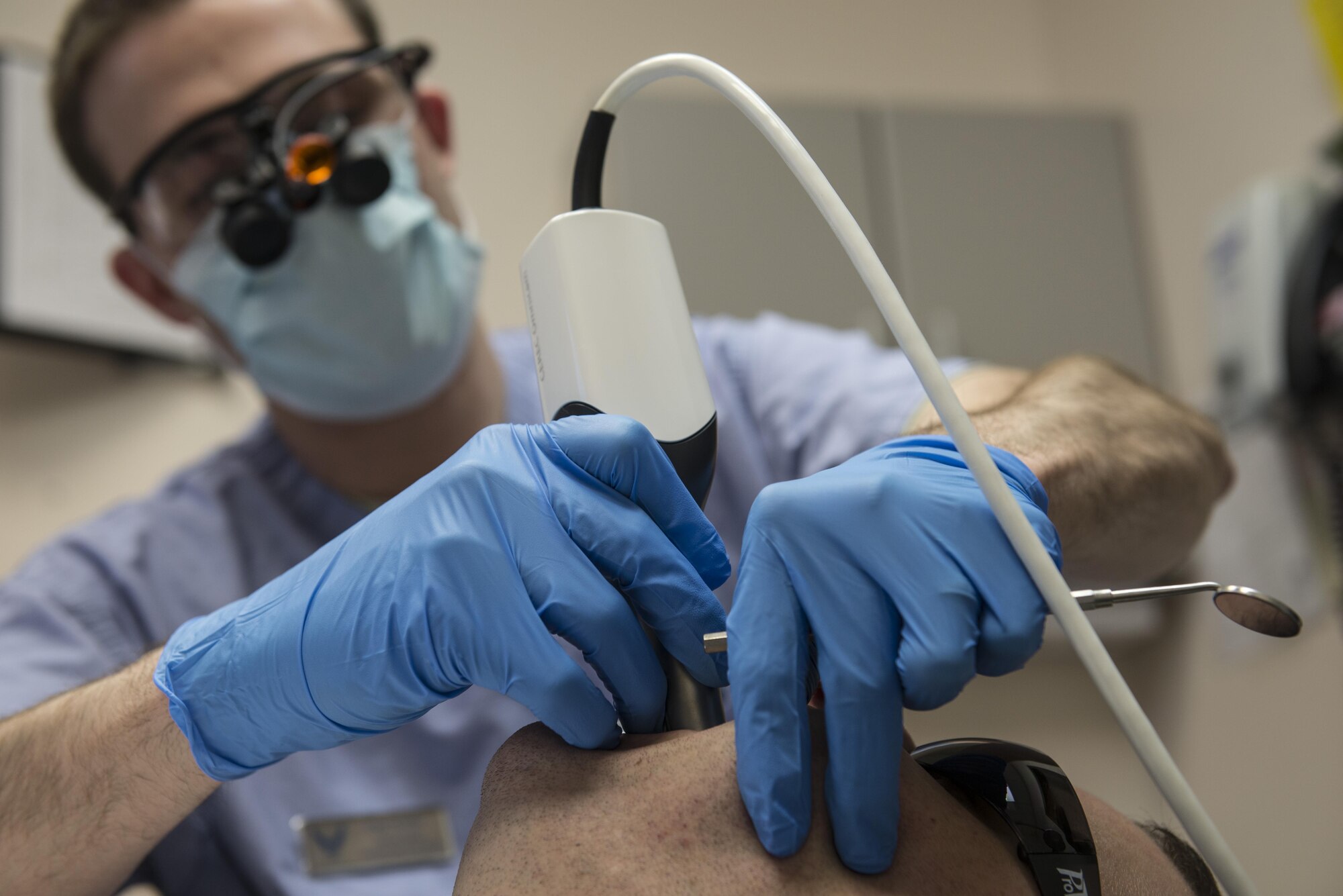 U.S. Air Force Capt. Jeffery Kohler, a 354th Medical Group general dentist, takes an optical impression of a patient March 21, 2016, at Eielson Air Force Base, Alaska. Optical impressions replaced the old wet impression process, decreasing the time needed to create a physical cast of a tooth. The new process reduced completion of crowns from three weeks to approximately two hours. (U.S. Air Force photo by Staff Sgt. Joshua Turner/Relased)