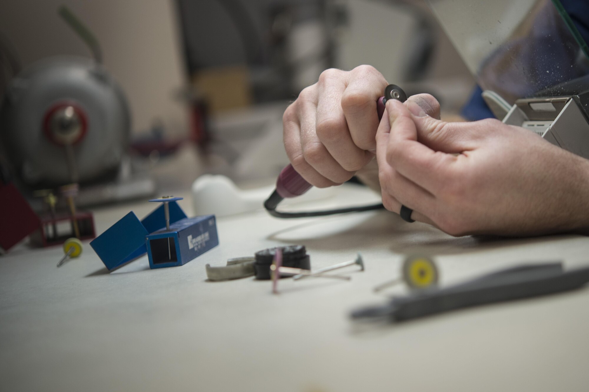 U.S. Air Force Tech. Sgt. Timothy McGee, a 354th Medical Group dental laboratory technician, polishes a porcelain crown March 21, 2016, at Eielson Air Force Base, Alaska. McGee manually applied finishing touches to the crown by making a series of adjustments to provide the patient with a proper fit. (U.S. Air Force photo by Staff Sgt. Joshua Turner/Relased)