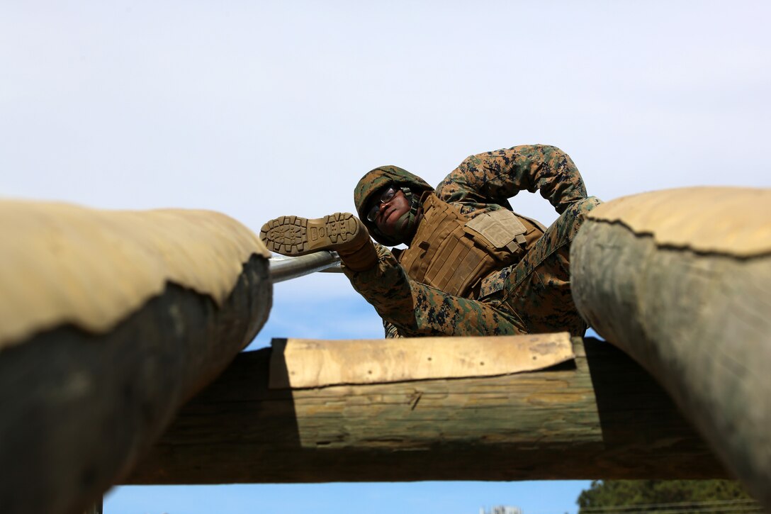 Cpl. Alex Kelly negotiates an obstacle during a team building exercise at Marine Corps Air Station Cherry Point, N.C., March 18, 2016. The obstacle course is utilized as a confidence builder for Marines as it challenges their physical and mental strength while encouraging leadership skills. Kelly is a food service specialist with Headquarters and Headquarters Squadron. (U.S. Marine Corps photo by Cpl. N.W. Huertas/Released)