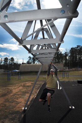 Chris Gallegos, 622nd Civil Engineer Group fire protection instructor shows his strength on a single horizontal bar at Dobbins Air Reserve Base, Ga., March 4, 2016. Gallegos will take part in the challenging Savage Race obstacle course April 9 and participated last year. (U.S Air Force Photo by Senior Airman Lauren Douglas)