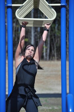 Natalie Campos, 22nd Air Force executive officer, hangs on tight as she practices upper-body strength on the bars at Dobbins Air Reserve Base, Ga., March 4, 2016. Campos will take part in the challenging Savage Race obstacle course held in Dallas, Ga., April 9. (U.S Air Force Photo by Senior Airman Miles Wilson) 