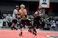 U.S. Air Force Maj. Jocelyn Smith, an executive officer with the 55th Wing Headquarters, skates past a blockade of Sioux City Roller Dames at the Ralston Arena, Neb., March 26, 2016. Smith, one a member of the Omaha Rollergirls, has been a participating in the roller derby sport for XX years.  (U.S. Air Force photo by Josh Plueger/Released) 